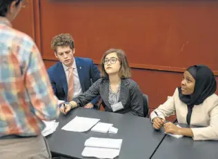  ?? Matthew Busch / Contributo­r ?? Members of the Human Rights Council of the annual Model United Nations San Antonio — Henry Livingston­e, from left, Alison Fowler and Fartun Yussuf — speak with a delegate.