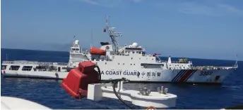  ?? — AFP photo ?? This handout photo shows Chinese coast guard vessel with bow number 3302 (back) blocking Philippine coast guard ship BRP Teresa Magbanua near Scarboroug­h shoal, in the disputed South China Sea. The Philippine Coast Guard accused Chinese vessels of “dangerous” manoeuvres during a nine-day patrol near a reef off the coast of the Southeast Asian country.