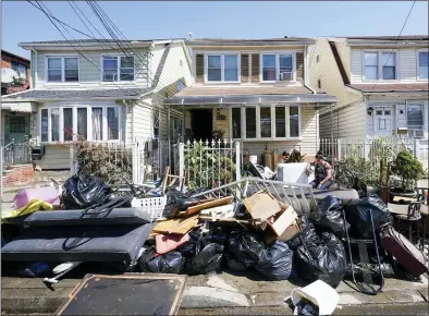  ?? MARY ALTAFFER-ASSOCIATED PRESS ?? A resident of 153rd St. in the Flushing neighborho­od of the Queens borough of New York sits outside her home with her water logged belongings, Thursday in New York.