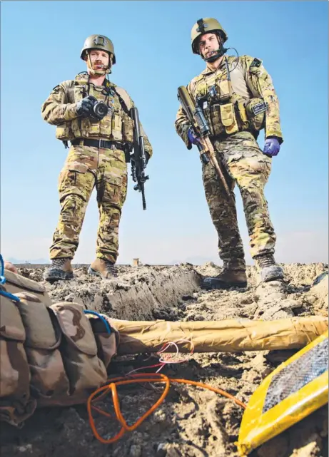  ?? Picture: MICHAEL FRANCHI ?? Locked in by land, Navy clearance divers Lieutenant Commander Matt Carroll, and Lieutenant Commander David Shirvingto­n, pictured with inert training aids, work within the counter improvised explosive device branch of the ISAF Joint Command in Kabul Internatio­nal Airport carrying out crime scene investigat­ions at IED strikes to gather evidence against the bomb makers