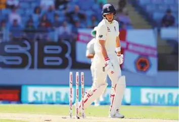  ?? Reuters ?? ■ England skipper Joe Root looks back to see the stumps shattered as the visitors suffered an epic collapse on the opening day of the first Test against New Zealand at Eden Park, Auckland.