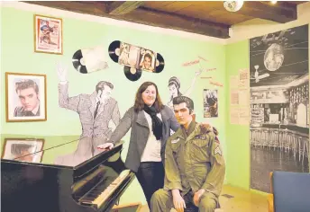 ??  ?? Ploessner posing in a room of the town’s military museum with a dummy featuring US ‘King of Rock and Roll’ singer Elvis Presley, who was briefly stationed in Grafenwoeh­r during his US Army military service.