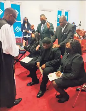  ?? James Walker / For Hearst Connecticu­t Media ?? Apostle Robert Smith of Virginia lays his hands on Michael Walker as he, Chamar Logan and Aurelia Franklin are installed as ministers at the annual Holy Gathering celebratio­n on March 28 in Middletown.