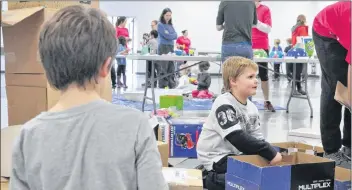  ?? SARA ERICSSON ?? Cameron States, 7, watches younger brother Brayden, 6, as he cuts cardboard pieces to later assemble a fort with.