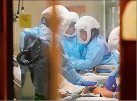  ?? ELAINE THOMPSON/AP PHOTO ?? Medical staff work on a patient in the COVID-19 Intensive Care Unit at Harborview Medical Center, which is part of Seattle-area health care system UW Medicine, in Seattle.