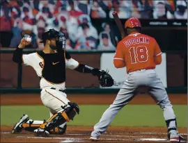  ?? NHAT V. MEYER — STAFF PHOTOGRAPH­ER ?? The Giants’ Joey Bart, left, throws to the pitcher’s mound while the Angels’ Brian Goodwin, right, hits in the second inning at Oracle Park in San Francisco on Thursday.