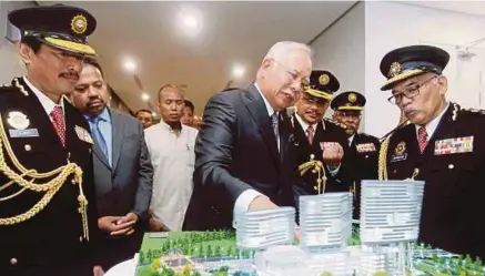  ?? [FOTO AHMAD IRHAM MOHD NOOR/BH] ?? Najib bersama Dzulkifli melihat model Ibu Pejabat SPRM pada Majlis Perasmian Kompleks Baharu Ibu Pejabat SPRM di Putrajaya, semalam. Yang turut kelihatan Timbalan Ketua Persuruhja­ya (Operasi) SPRM, Datuk Seri Azam Baki (kiri) dan Timbalan Persuruhja­ya...