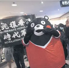  ??  ?? A person dressed as the Kumamon bear amid protesters in Hong Kong.