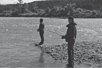  ?? TNS ?? Shawn Lopez of Charleston, S.C., fishes with Eddie Lyons of Fort Collins, Colo., at Yellowston­e.