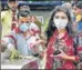  ??  ?? Commuters wearing masks exit a Delhi Metro station as a staffer disinfects the premises.