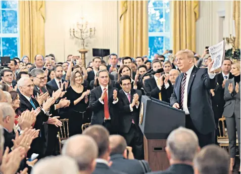  ??  ?? Donald Trump holds yesterday’s Washington Post with the headline ‘Trump acquitted’ during a speech to supporters in the White House. Above left, with his wife Melania