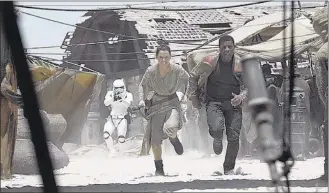  ??  ?? Daisy Ridley as Rey and John Boyega as Finn in “Star Wars: The Force Awakens.”