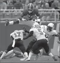  ?? The Associated Press ?? HIGH-FLYING HARRIS: Alabama running back Najee Harris leaps over Mercer defensive back Eric Jackson (17) during the first half of Saturday’s game in Tuscaloosa, Ala.