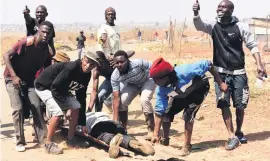  ?? Picture: Nigel Sibanda ?? CASUALTY. Unaville residents with an injured man.