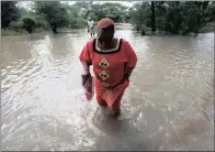  ??  ?? Former Zimbabwean Deputy Prime Minister Thokozani Khupe crosses a flooded road on her way to assess damages caused by floods in Tsholotsho, about 200km north of Bulawayo. The country needs as much as $200 million in humanitari­an and infrastruc­ture rebuilding aid.