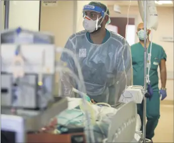  ?? LUCA BRUNO/AP ?? Amid a resurgence of the pandemic, doctors transport a coronaviru­s patient Nov. 6 at Circolo Hospital in Varese, Italy.