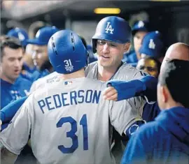  ?? Wally Skalij Los Angeles Times ?? JOC PEDERSON gets a hug from Cody Bellinger after Pederson’s three-run home run in the ninth inning Saturday in Game 4 of the World Series in Houston.