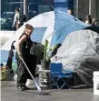  ?? PHOTO: AAP ?? MOVING ON: Cleaning up the tent city.