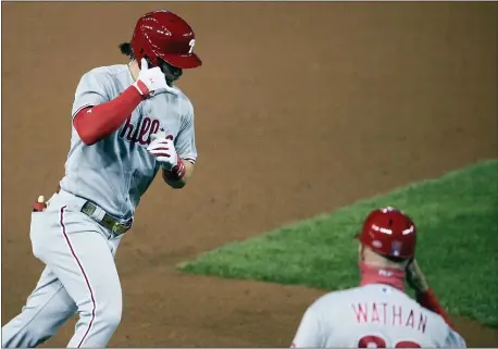  ?? NICK WASS — THE ASSOCIATED PRESS ?? Phillies’ Bryce Harper, left, celebrates his home run with third base coach Dusty Wathan during the sixth inning of Wednesday’s game against the Nationals.