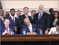  ?? (AP/Brian Witte) ?? Maryland Gov. Wes Moore signs legislatio­n Tuesday in Annapolis, Md., to help employees of the Port of Baltimore affected by the Francis Scott Key Bridge collapse. It authorizes use of the state’s rainy day fund to provide financial help.