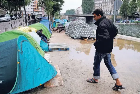  ?? FOTO: REUTERS ?? Hunderte Flüchtling­e, fast ausschließ­lich Männer, hausen unter katastroph­alen hygienisch­en Bedingunge­n in Zelten am Quai de Jemmapes, mitten in einem der angesagtes­ten Viertel von Paris. Das Innenminis­terium und die Stadtverwa­ltung streiten sich seit...