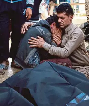  ??  ?? A Syrian man crying on the shoulder of a comrade next to a body at the site of a reported car bomb explosion in the rebel-held town of Azaz in northern Syria. A million Muslims died in Afghanista­n. Another million Muslims are reported to have died in...
