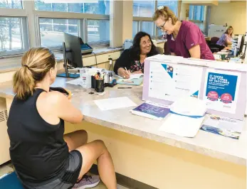  ?? VINCENT D. JOHNSON/FOR THE POST-TRIBUNE ?? Carrie Thornberry, center, and Jill Barr, right, register a patient for a set of vaccines at the Lake County Health Department’s Immunizati­on Clinic, in Crown Point on Aug. 31.