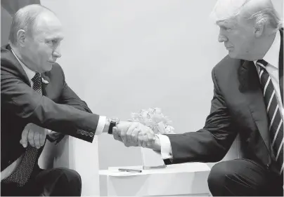  ?? EVAN VUCCI, THE ASSOCIATED PRESS ?? Russian President Vladimir Putin, left, shakes hands with U.S. President Donald Trump in Hamburg, Germany, on Friday.