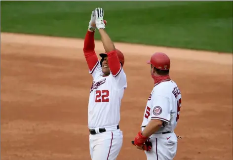  ?? AP PHOTO/NICK WASS ?? Washington Nationals’ Juan Soto (22) reacts at first after his single during the second inning of a baseball game against the New York Mets, Sunday, in Washington. Also seen is Nationals first base coach Bob Henley at right.