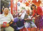  ?? –AMIRUL SYAFIQ/ THESUN ?? Phang handing out Ang Pow packets to senior citizens from Rumah Kasih Charity Home.