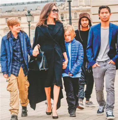  ??  ?? Brad Pitt pide la custodia compartida de sus seis hijos, tres adoptivos y tres biológicos. Aquí, todos con su madre, Angelina Jolie, en febrero pasado, a las puertas del Museo de Louvre.