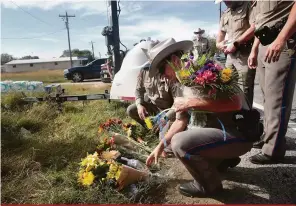  ?? Scott Olson/Getty Images/AFP ?? Moradores da pequena cidade, com cerca de 400 habitantes, depositam flores nas proximidad­es da igreja onde houve o massacre