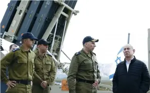  ?? (Jack Guez/Reuters) ?? PRIME MINISTER Benjamin Netanyahu stands with IDF soldiers near the Iron Dome intercepto­r system in Haifa last week.