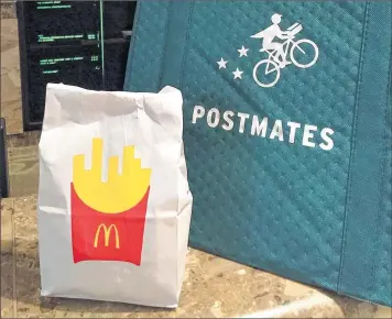  ??  ?? A bag of food from Mcdonald’s ordered through the Postmates service sits next to a Postmates delivery bag Wednesday during a delivery in New York.