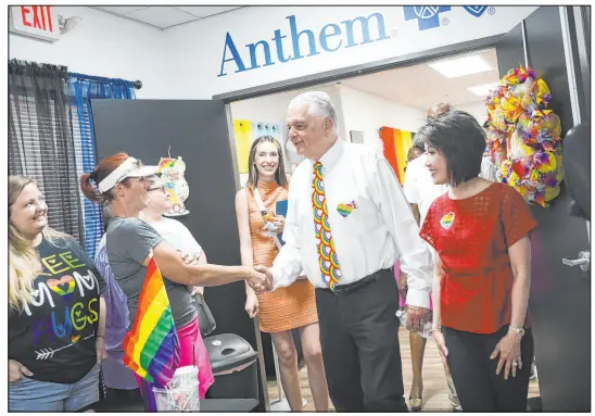  ?? Rachel Aston Las Vegas Review-journal @rookie__rae ?? Gov. Steve Sisolak greets vendors alongside his wife, Kathy, as they tour the Henderson Equality Center during a Pride Month festival on Sunday in Henderson. Sisolak was on hand to sign four bills aimed at improving LGBTQ equity.
