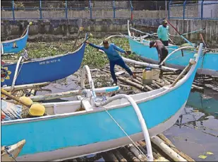 ?? EDD GUMBAN ?? Fishermen in Navotas secure their bancas yesterday in preparatio­n for the onslaught of Super Typhoon Ompong, forecast to make landfall over the Cagayan-Batanes area tomorrow.