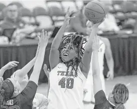  ?? John Locher / Associated Press ?? Texas’ Jatarie White (40) shoots over Washington’s Khayla Rooks, left, and Mackenzie Wieburg, right, for two of her 24 points in the Longhorns’ victory.