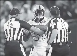  ?? EZRA SHAW — GETTY IMAGES ?? Raiders running back Marshawn Lynch is restrained after coming off the bench and shoving a referee during a scrum with the Kansas City Chiefs in Thursday’s game.