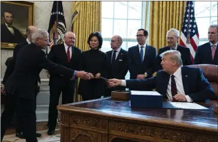  ?? EVAN VUCCI — THE ASSOCIATED PRESS ?? President Donald Trump hands a pen to Dr. Anthony Fauci, director of the National Institute of Allergy and Infectious Diseases, after signing the coronaviru­s stimulus relief package at the White House on Friday.