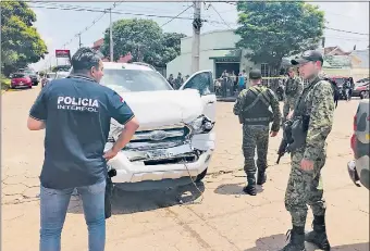  ??  ?? Policías de Interpol y del Grupo Especial de Operacione­s (GEO) rodean la camioneta blindada en la que se movilizaba la víctima del atentado.