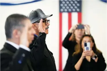  ?? AP PHOTO/GREGORY BULL ?? On Wednesday, deported veterans Leonel Contreras, center, and Mauricio Hernandez Mata, left, are sworn in as U.S. citizens at a special naturaliza­tion ceremony in San Diego.