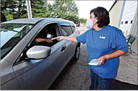  ?? THOMAS WELLS / NORTHEAST MISSISSIPP­I DAILY JOURNAL, VIA AP ?? Dana Renner continues to hand out five-pack bags of masks to residents Tuesday at the Lee County Multipurpo­se Center in Tupelo, Mississipp­i. The center will give out over 16,000 masks.