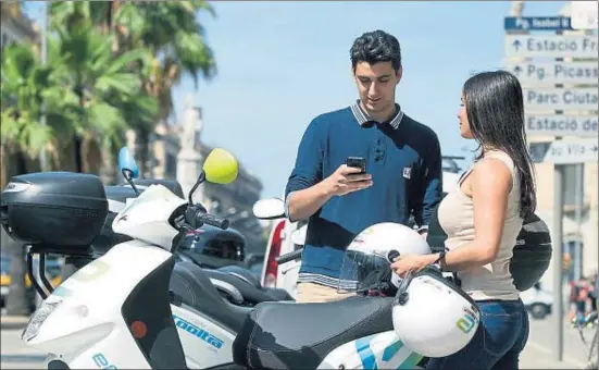  ?? XAVIER GÓMEZ ?? Pau Subirats y Marta Cillero desbloquea­n una moto compartida usando la aplicación del teléfono móvil