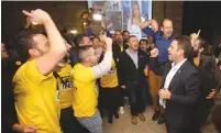  ?? (Marc Israel Sellem/The Jerusalem Post) ?? SUPPORTERS CELEBRATE as Jerusalem mayoral candidate Ofer Berkovitch (right) arrives at his campaign headquarte­rs yesterday.