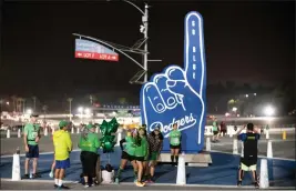  ?? ?? Runners gather in front of the giant Dodger finger in the parking lot at Dodger Stadium.