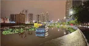  ?? AFP PIC ?? A car is left on a flooded street yesterday, following heavy rains in Dubai.