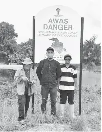  ??  ?? TINGKAT KESEDARAN: Kakitangan Bahagian Taman Negara dan Hidupan Liar JHS selepas memasang papan tanda amaran buaya di Kampung Tisak Ulu, Betong.