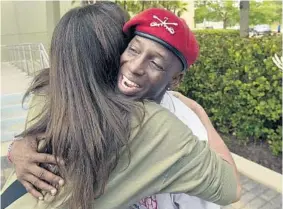  ?? MICHAEL LAUGHLIN/STAFF PHOTOGRAPH­ER ?? Romero “Black Cat” Davis receives a hug as Parkland residents honored the three Guardian Angels who have been patrolling Marjory Stoneman Douglas High School. Principal Ty Thompson presented the Guardian Angels with the school’s coveted Eagle award...