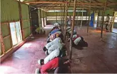  ?? AFP ?? Rohingya men offer afternoon prayers at a refugee camp in Ukhia, Cox’s Bazar. While they acknowledg­e they were lucky to escape, refugees say food and money are scarce.