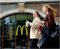  ?? IN MOSCOW ON MONDAY. — afp ?? Women walk past a Mcdonald’s restaurant